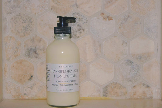 A bottle of Kind of Sea Passiflora Isle Honeycomb body and hand cream, featuring a black pump and white label, set against a beige hexagonal tile background.
